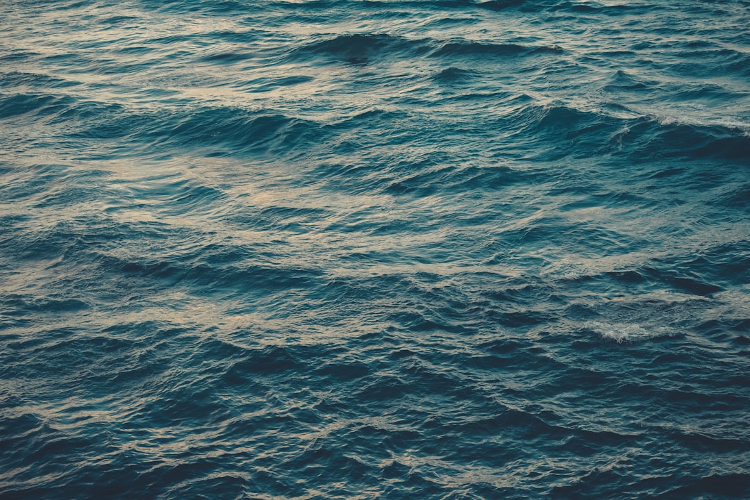 a large body of water with a boat in the distance
